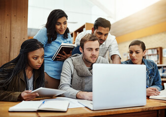 Education, students and laptop for discussion in library with research project, learning and assignment teamwork. Diversity study group, books and people with planning at college for test preparation