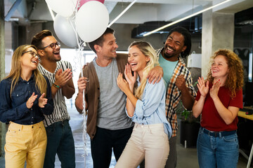 Friendly diverse employees congratulating businesswoman with business achievement
