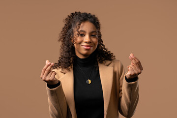 Young african teen girl, money gesture on studio background. Smart lady smiles