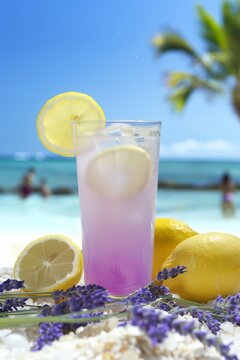 Refreshing lavender lemonade served by the beach on a sunny day, with vibrant colors and tropical vibes