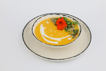 Tasty pumpkin Soup with cream in a bowl on a white background