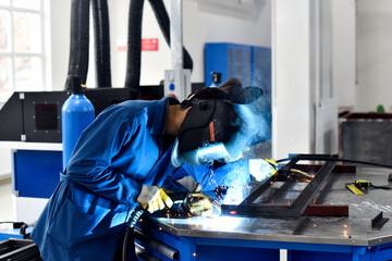 Workers welding in workshop, factory
