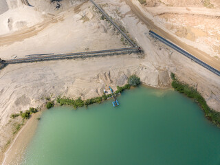 Aerial - drone view of Sand quarry with industrial structures and artificial lake.