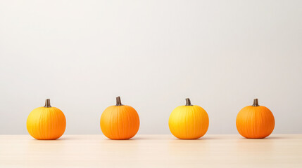 lineup of four orange pumpkins on white surface for autumn decor