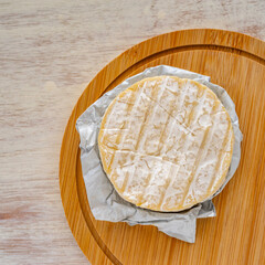 Camembert cheese on wooden background.
