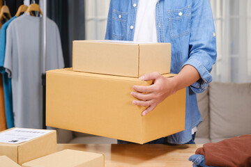 Portrait of a confident young online entrepreneur working from his home office, surrounded by clothing products and shipping boxes.
