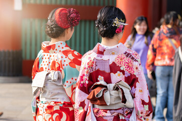 Young girl wearing Japanese kimono standing in front of Sensoji Temple in Tokyo, Japan. Kimono is a Japanese traditional garment. The word "kimono", which actually means a "thing to wear"