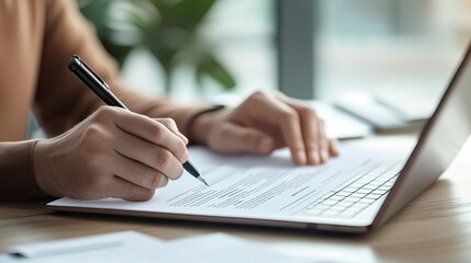 A close-up of a person filling out a job application form on a laptop, with a focused expression.