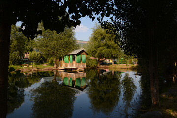 Obraz premium Wooden house by the lake. Cottage on the river bank. Cottage for rest. House in the forest
