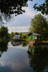 Obraz premium Wooden house by the lake. Cottage on the river bank. Cottage for rest. House in the forest