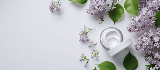 Spa concept cream in a glass jar alongside a white cream tube featuring lilac flowers and green lilac leaves on a white background copy space