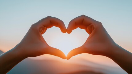 Obraz premium Two hands forming a heart shape, with a sunset in the background