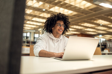 University graduate searching for information for his project on laptop