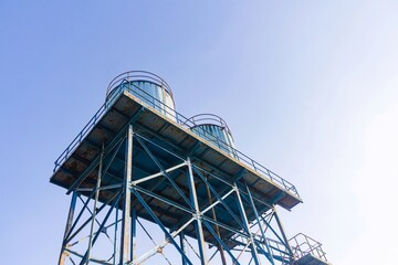 low angle view of water tower with bright blue sky background. no people.