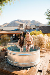 Two beautiful girls pose in a cowboy tub in Joshua Tree, California.