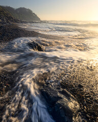 sunset on the beach at minnie water with waves on pebbly beach