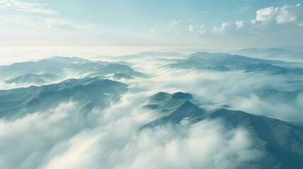 Fototapeta premium Aerial perspective of rolling hills covered in fog, with only the peaks of the hills visible, creating a soft, dreamlike scene where land and sky blend together