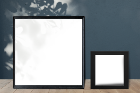 Black picture frame mockups leaning against a gray wall