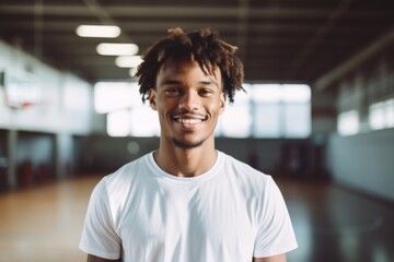 Obraz premium Portrait of a smiling male African American teenager in basketball gym