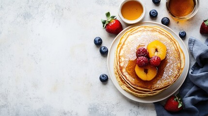 Stack of pancakes with syrup, fruit, and powdered sugar on a white background.