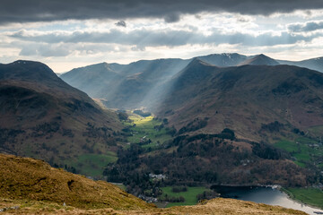 Naklejka premium Sun rays beaming into the valley in the mountains