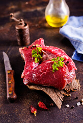 Raw meat with herbs and garlic, marble meat. Wooden background. Top view.