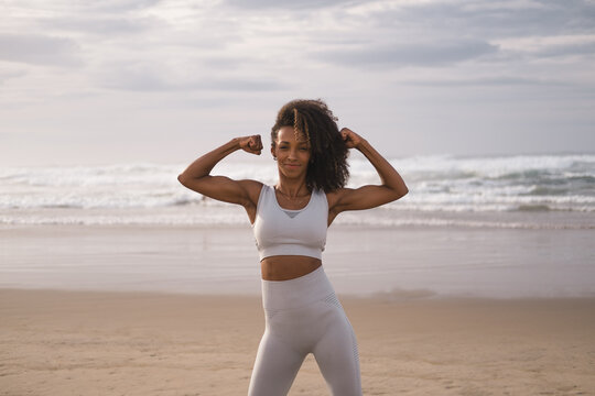 Outdoor portrait of motivated black female fit woman at the beach. Fitness lifestyle success and motivation concept.