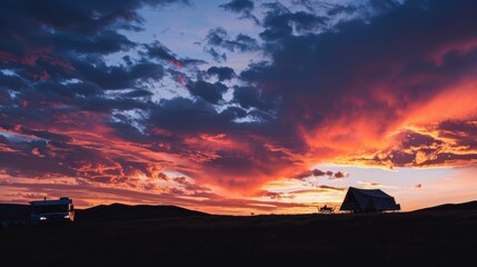 Travelers enjoying dramatic sunset over campsite with camper van and tent