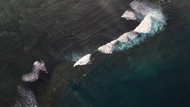 Aerial view of tropical reef with serene waves and pristine water, Fiji.
