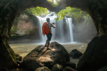 Obraz premium A man taking photo of the beauty of Haew Suwat Waterfall Khao Yai National Park Nakhon Ratchasima Province, Thailand.