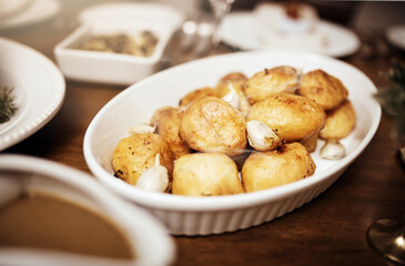 Potatoes, food and dinner with party, celebration event with glassware, Christmas and lunch at home for holiday. Table setting, feast and crockery for fine dining, December decoration and house