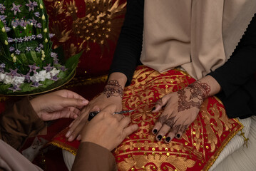 The process of painting henna on the bride's hands. There are many different names for henna tattoo across the globe, such as mehndi, inai, hina, camphire, and hena