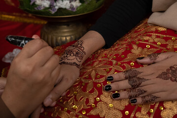 The process of painting henna on the bride's hands. There are many different names for henna tattoo...