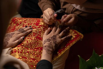 The process of painting henna on the bride's hands. There are many different names for henna tattoo...