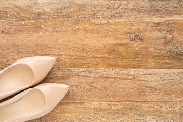 Women's dress shoes on wooden background with copy space.
