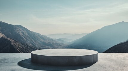 Concrete podium in front of a mountain range with a bright sky.