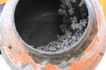 Mixing mortar in a handheld portable concrete mixer