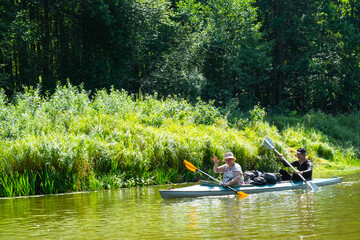 Family kayak trip for seigneur and senora. An elderly married couple rowing a boat on the river, a water hike, a summer adventure. Age-related sports, mental youth and health, tourism, active old age