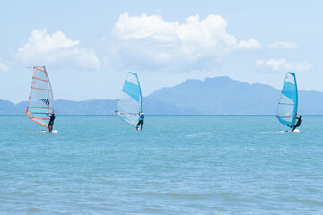 Windsurfers plays with the wind and ocean waves