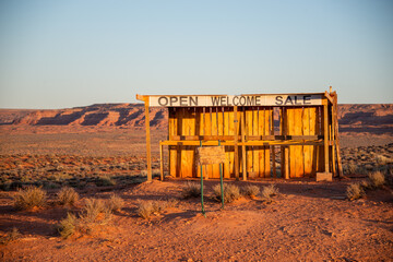 Abandoned roadside wooden vendor shack desert weathered monument valley