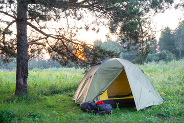 Installed tourist tent in a camping in nature in the forest. Domestic tourism, active summer holidays, family adventures. Ecotourism, sport, hike. Copy space, mock up