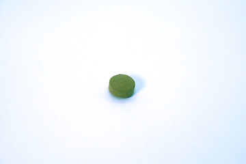 close up a green medicine  tablet on white background isolated