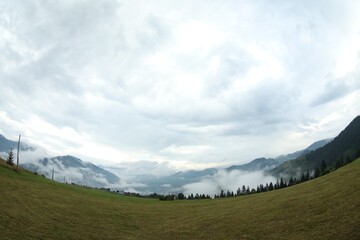 Picturesque view of beautiful mountains covered with fog. Fisheye lens effect