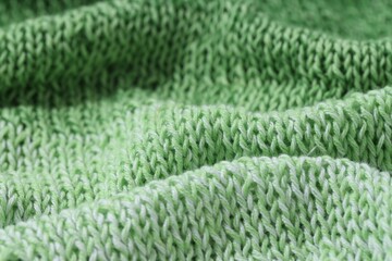 Texture of green knitted fabric as background, closeup