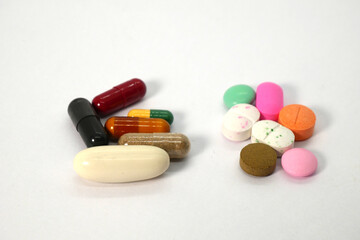 close up of colorful tablets, capsules, and pills in the golden spoon on the white background isolated