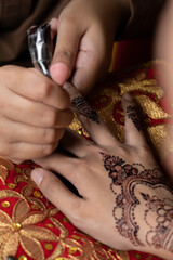The process of painting henna on the bride's hands. There are many different names for henna tattoo...