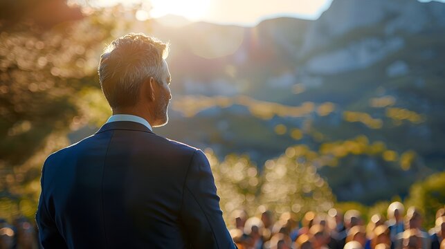 Business Leader Addressing Corporate Retreat Audience in Scenic Outdoor Setting
