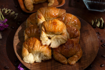 Butter croissants on a wooden plate with ingredients for breakfast or a snack and coffee beans 