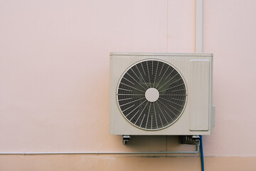Air compressor or air condenser unit located on support outside building to heat released...