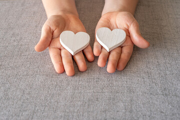 Decorative hearts in the hands of a child. Concept of love in the family.